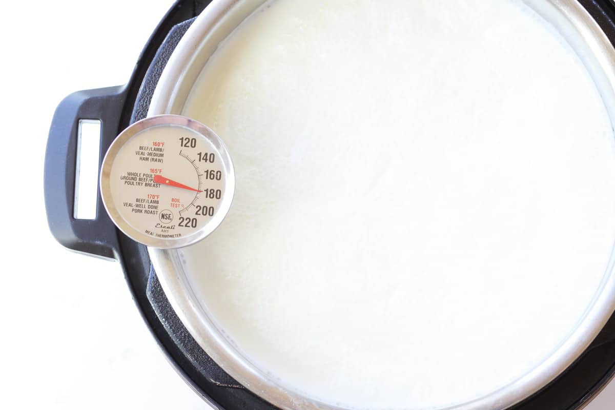 an instant pot of milk with a thermometer that reads 180 degrees