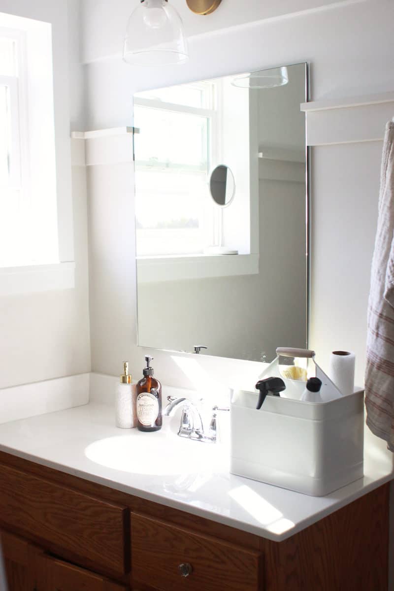 a bathroom with a cleaning caddy on the clean counter