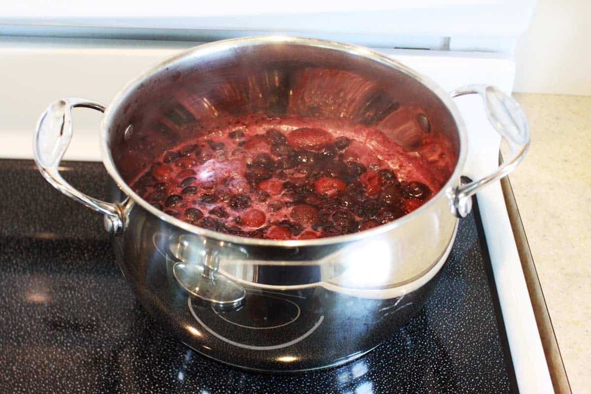 a pot of boiling mixed berries on a stovetop