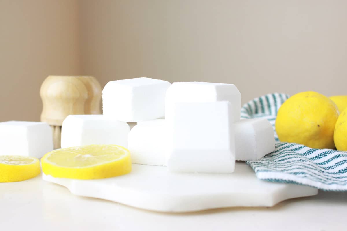 a marble cutting board with toilet bowl cleaner bombs and sliced lemons