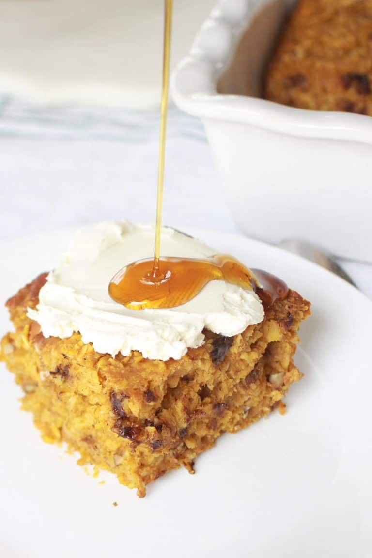 a plate with a serving on pumpkin baked oatmeal with chocolate chips in it and cream cheese and maple syrup on top