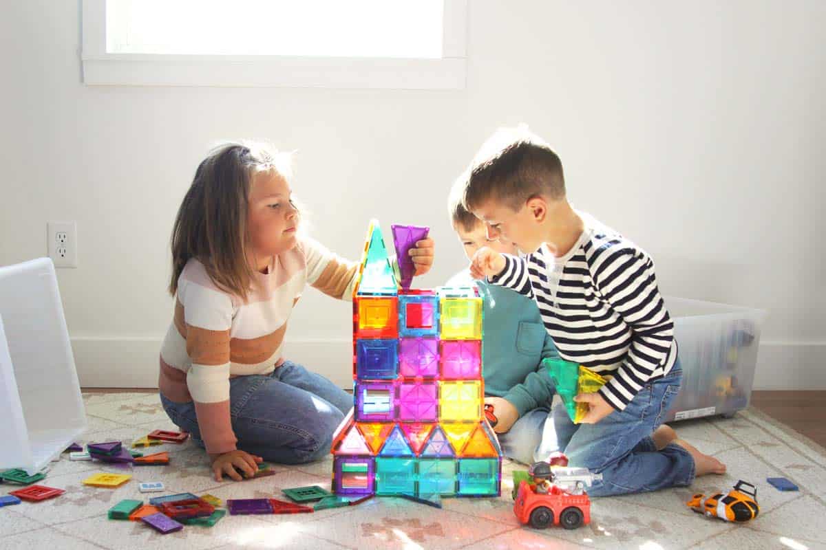 three kids playing with magnet tiles