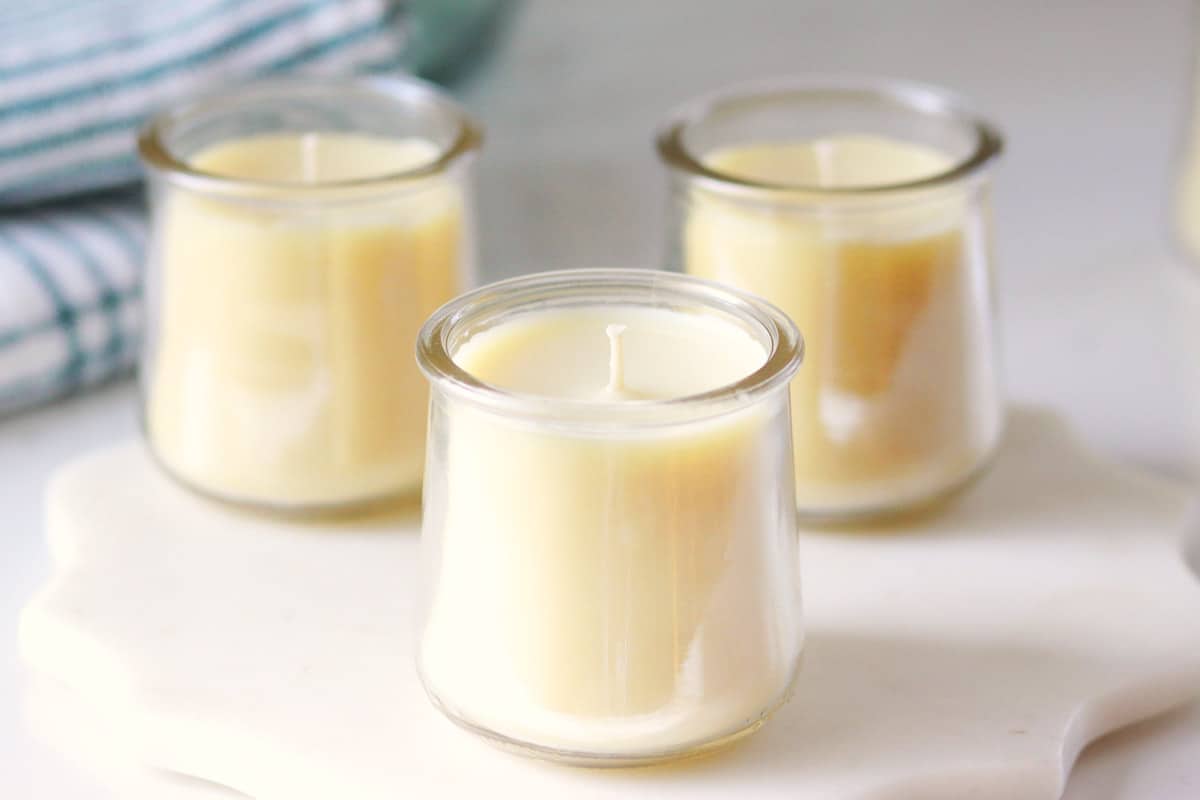 three beeswax candles in oui yogurt jars