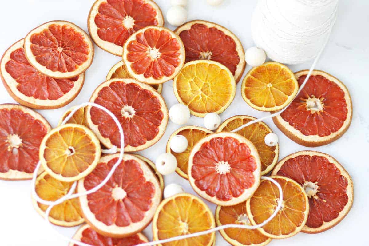 dried orange slices and grapefruit slices with wooden beads and string