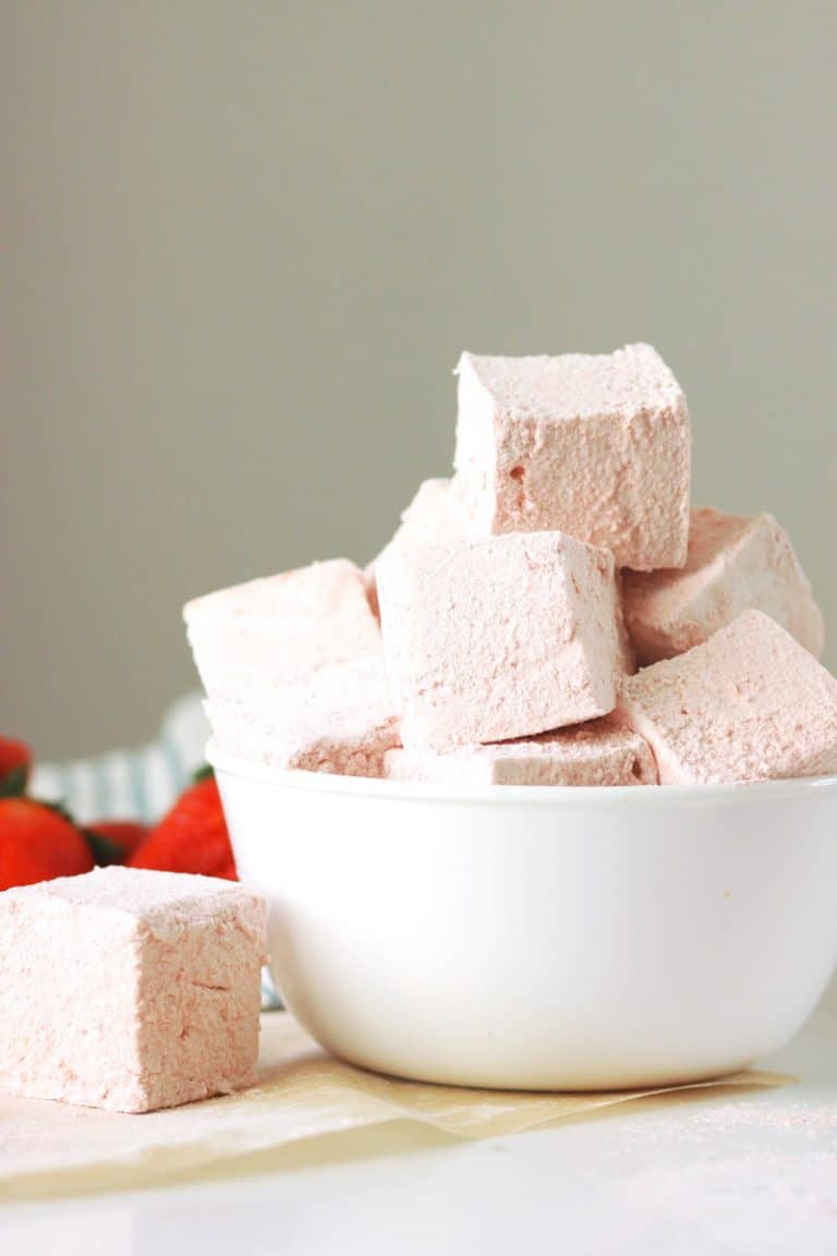 a bowl of strawberry marshmallows with fresh strawberries