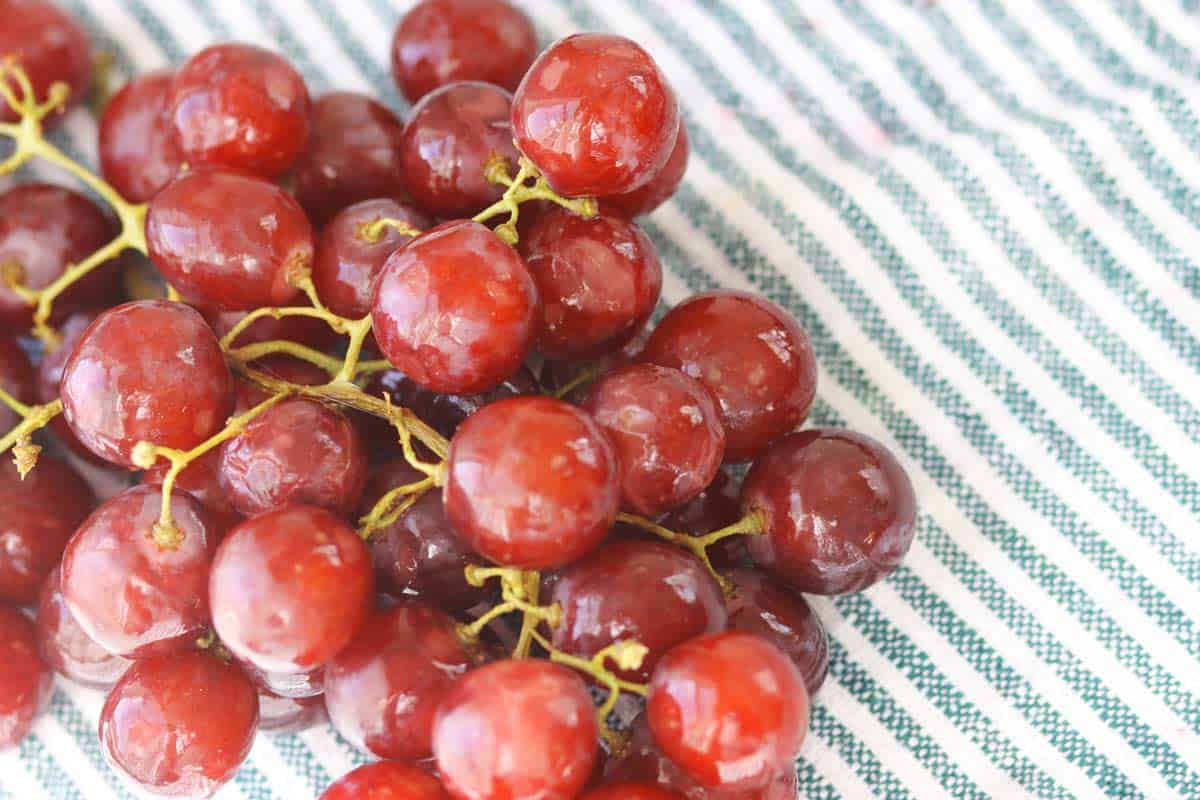 freshly washed grapes on a striped towel