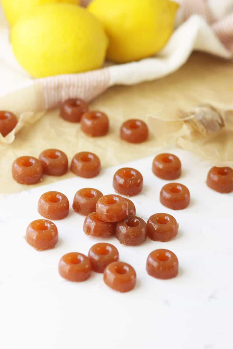 ginger hard candy on a marble countertop with lemons in the background