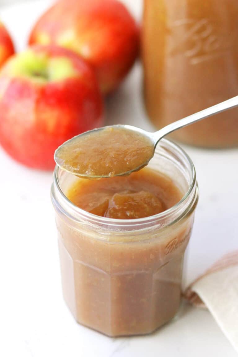 cinnamon applesauce in a mason jar with apples in the background