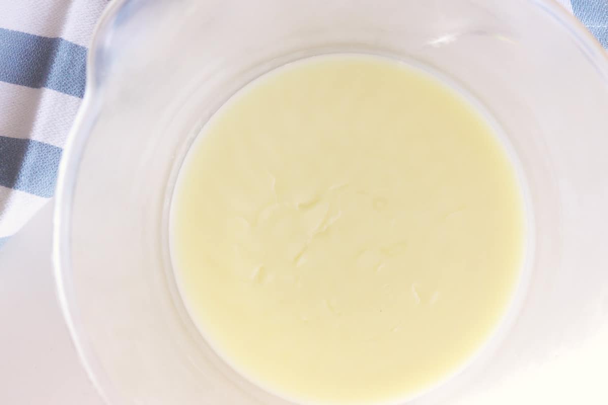 a beeswax body butter mixture in a clear glass bowl