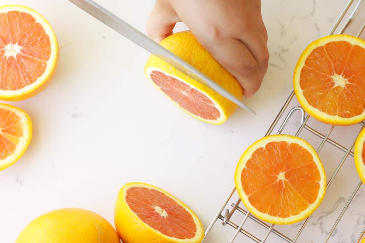 a girl slicing oranges with a sharp knife