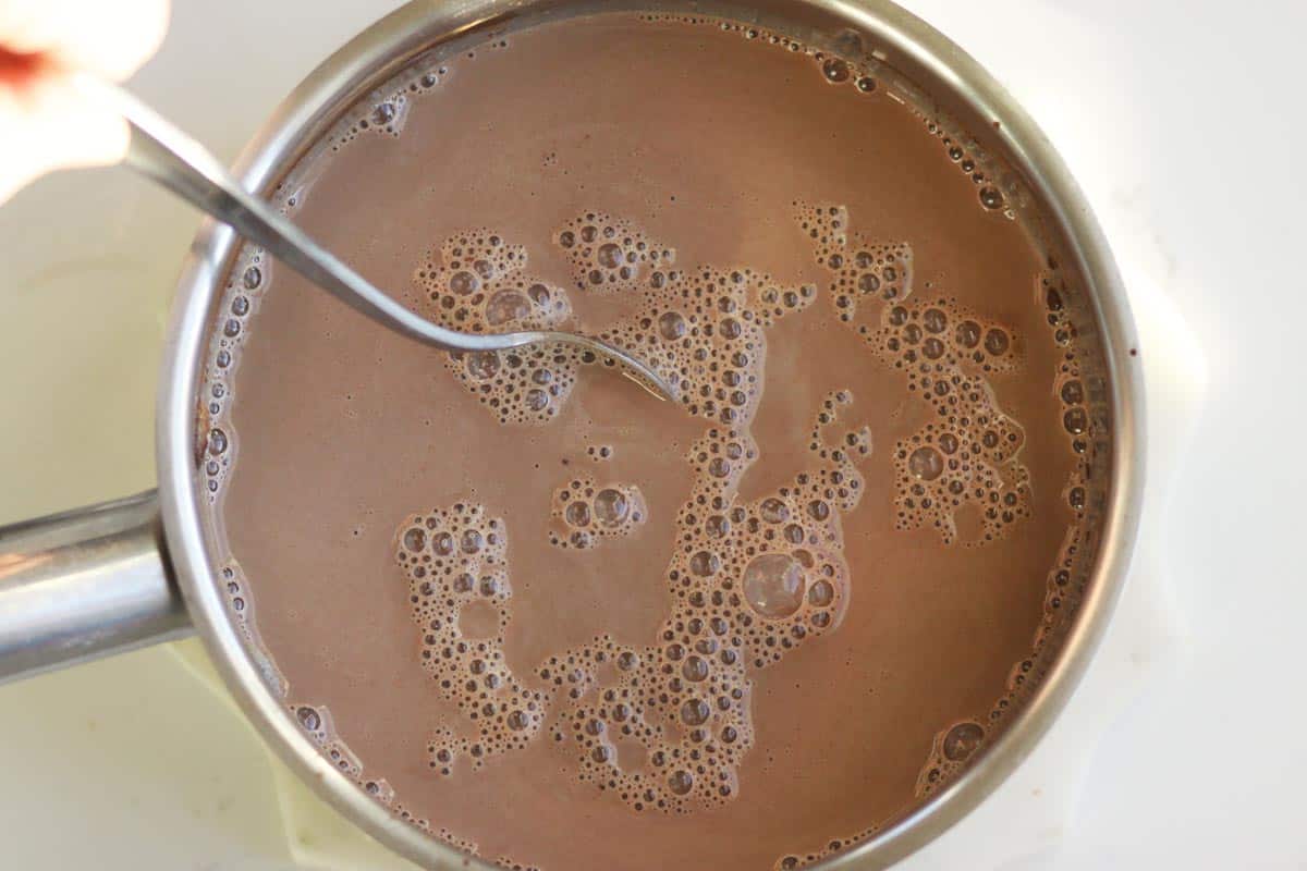 a saucepan of bubbly homemade chocolate milk