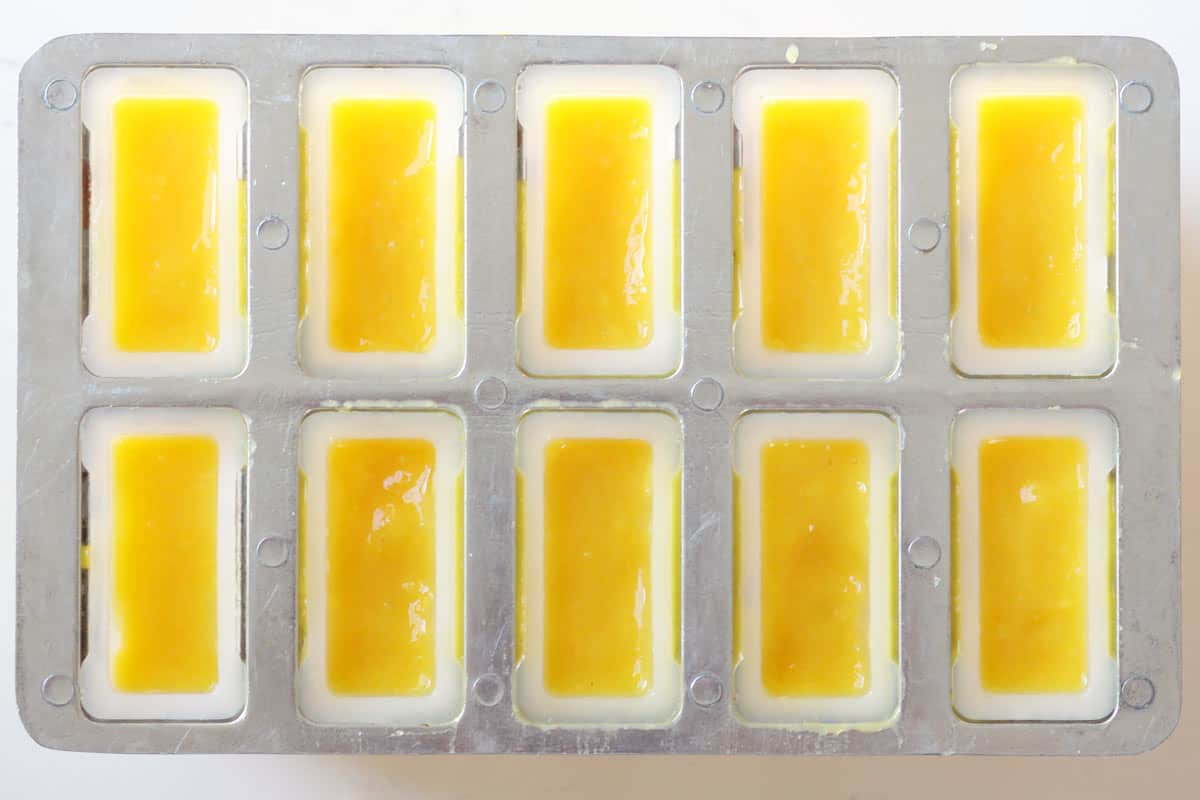 a popsicle mold filled with mango puree